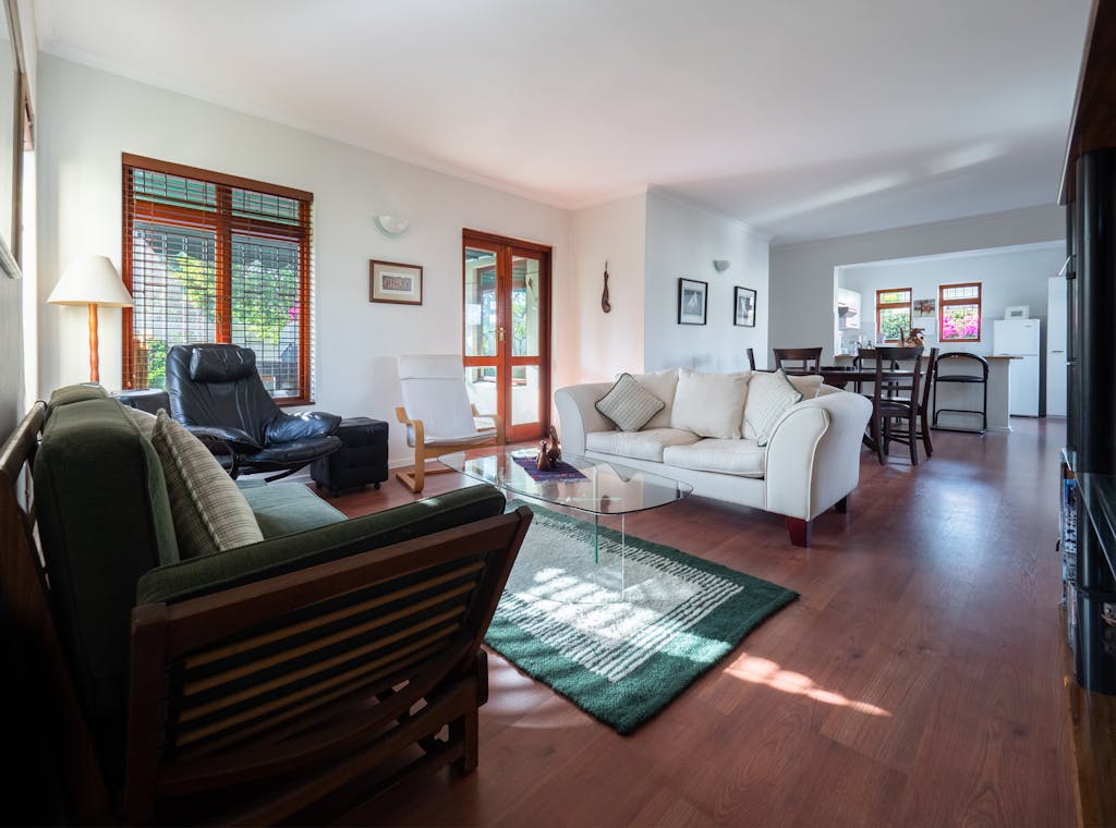 Spacious living room with modern furniture and wooden flooring.